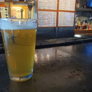 a glass of beer on a bar