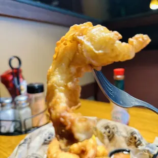 a fork in a basket of fried shrimp