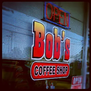 small strip mall location...window sign...mostly dirt parking...