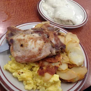 pork chops, scrambled eggs, country potatoes, and biscuits and gravy.
