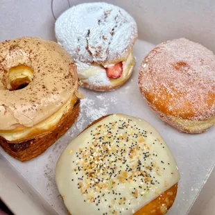 coffee donut on top of a chocolate covered cronut, strawberry shortcake, Hawaiian custard, and chive cream cheese everything donut
