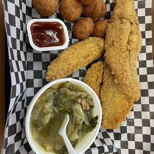 Fried Catfish with potato wedges, greens and hush puppies.