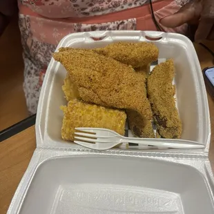 Fried catfish, fried corn on the cob, potato wedges