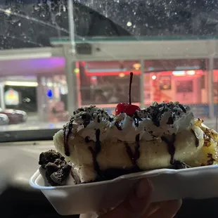 a hand holding a banana split