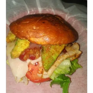 a burger with lettuce, tomato, and pickles