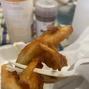 a close up of a fork holding a piece of fried food