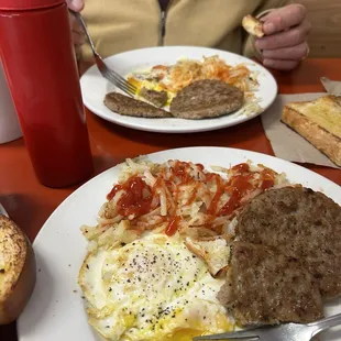 a plate of food with eggs, sausage, and bread