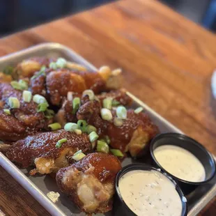 a tray of chicken wings and dips