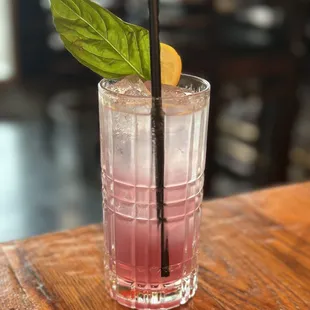 a pink drink with a green leaf garnish