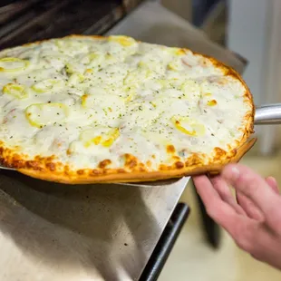 a pizza being taken out of the oven