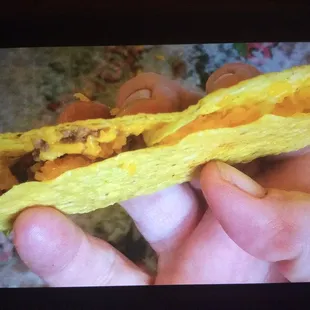 a hand holding a taco