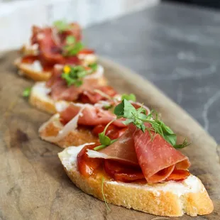 a wooden cutting board topped with slices of bread