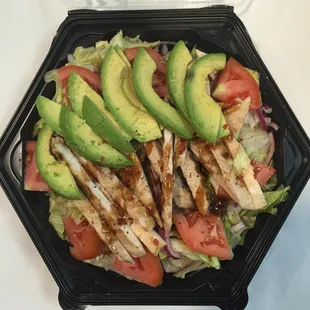 a chicken salad with avocado and tomatoes