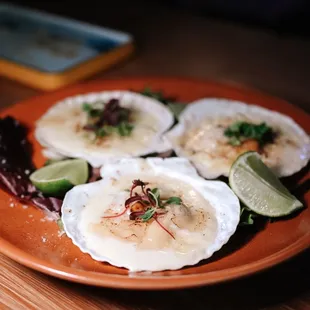 three scallops on an orange plate