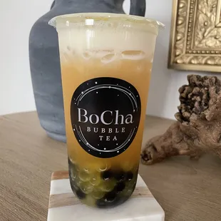 Pineapple fruit tea with brown sugar boba and passion fruit popping boba