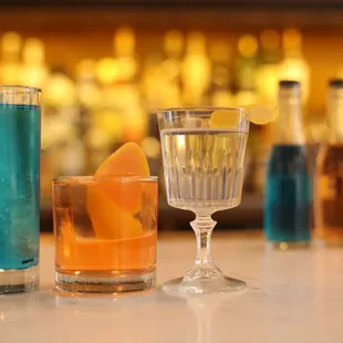 a variety of cocktails on a bar counter