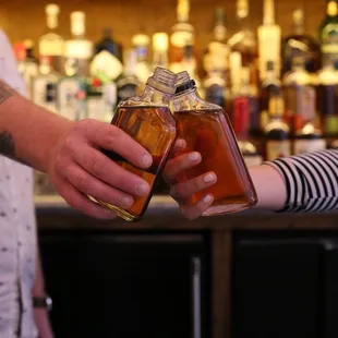 a man handing a bottle of liquor to a woman