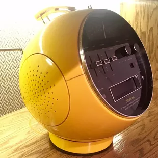 a yellow alarm clock on a wooden table