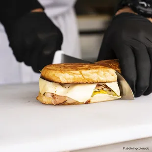 a person cutting a sandwich