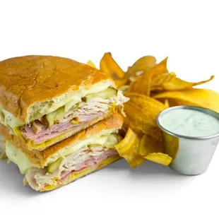 Turkey Media Noche: Oven Roasted Turkey, Thin Sliced Ham, Melted Swiss, Mustard &amp; Pickles. Served w/Plantain Chips &amp; Garlic Cilantro Sauce