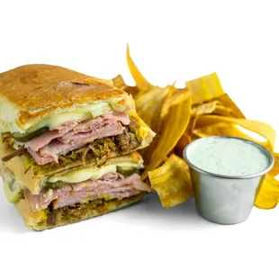 Cuban Sandwich: Slow Roasted Pork, Sliced Ham, Swiss, Mustard &amp; Pickles.  Served w/Plantain Chips &amp; Garlic Cilantro Sauce