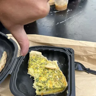a person taking a piece of food out of a plastic container