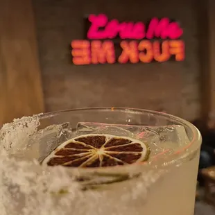 a close up of a cocktail with a slice of orange