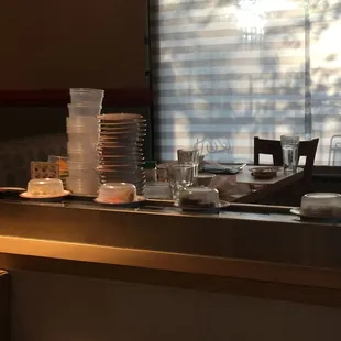 Stacked plates of eaten conveyor sushi at the table across from us.