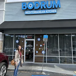 a woman standing in front of a restaurant