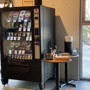 Charcuterie vending machine with clean boards and knives to plate the delicious cheeses, crackers, olives, chocolate, and more!
