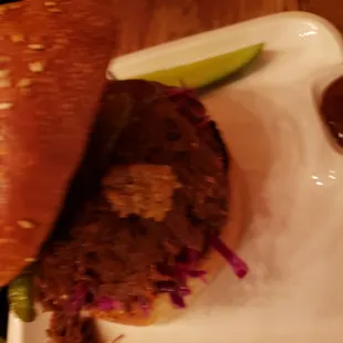 a person holding a sandwich on a plate