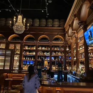 a woman standing in front of a bar