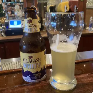 a beer and a glass on a bar