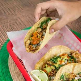 two tacos being held by a person