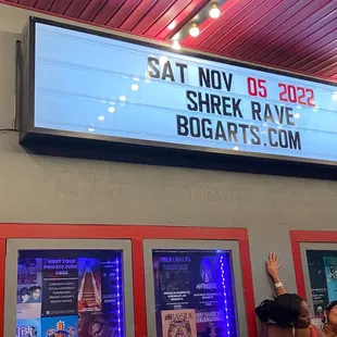 a woman in a red dress waving