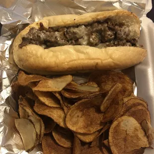 a hot dog and chips in a styrofoam container