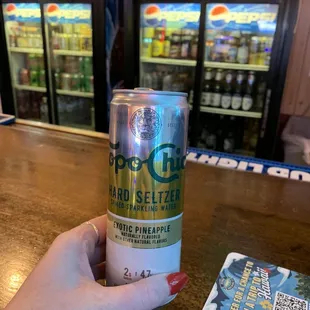 a person holding a can of beer