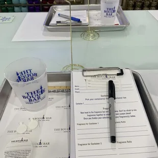 a notepad, pen, and cup on a table