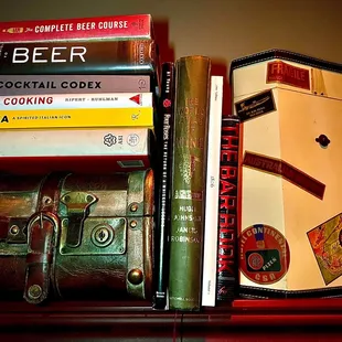 a shelf of books and liquor