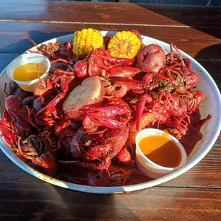 a plate of craws, corn, and potatoes