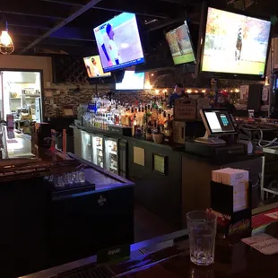 a bar with several televisions above the bar