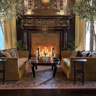 a living room with a fireplace, couches, and tables
