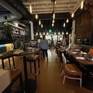 a restaurant with tables, chairs, and people