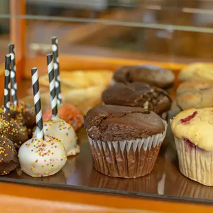 a tray of cupcakes and muffins