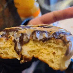 a hand holding a half eaten donut