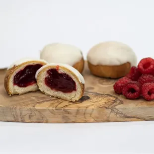 raspberries and a pastry on a cutting board