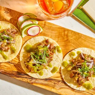 three tacos on a cutting board