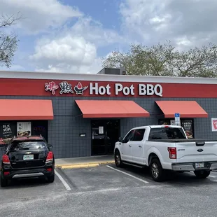 two pickup trucks parked in front of a bbq