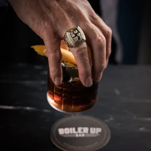 a man's hand holding a cocktail glass