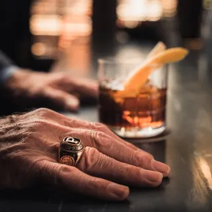 a man's hand holding a cocktail glass